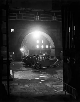 Moody Prints: London by Night. View of motor cars parked outside Old Scotland Yard