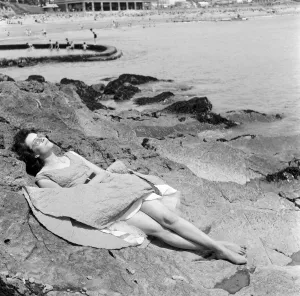 Holiday Prints: Londoner Pauline Weller, 20, sunbathes on the rocks at Porthcawl, Mid Glamorgan, Wales