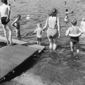 Londons Hyde Park Lido. A mother helps her child into the Serpentine