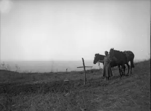 A lone Russian soldier stands by a mass grave in Galicia where the bodies of fifty