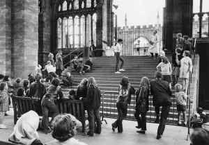 Long haired leather jacketed girls and boys watching a scene from this rehearsal of