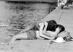 Love and Romance. A young couple oblivious to their surrounding seen here kissing beside