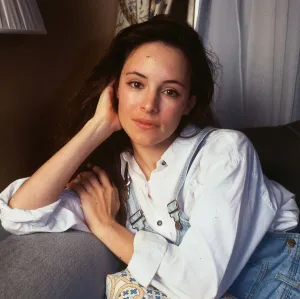 Madeline Stowe actress leaning on sofa hand at face head