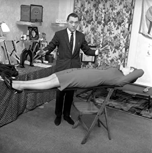 Magician Bernard Hughes: Performing a levitation trick on his female assistant
