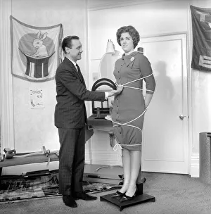 Magician Bernard Hughes performing rope trick with female assistant