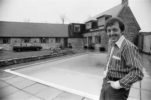 Magician Paul Daniels beside his swimming pool and house in Buckinghamshire