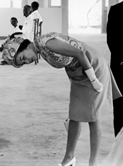Asia Prints: Her Majesty Queen Elizabeth II bends down to have a closer look under the frame of one of