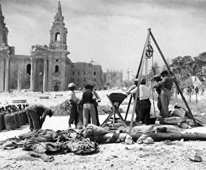 01459 Prints: Maltese workmen hauling and measuring grain from one of the underground granaries in
