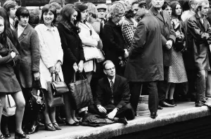 Tired Prints: One man decides to sit down on the platform as homeward bound crowds await their train