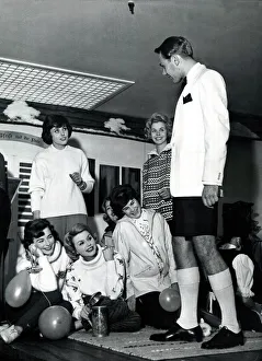 A man dressed in dinner jacket and shorts for dinner at the captains table on the cruise