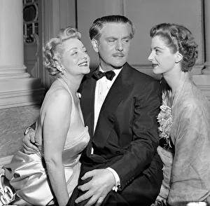 Tuxedo Prints: A man dressed in a smart evening suit with bow tie talking to two glamorous women at a