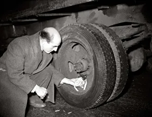 Wheels Prints: A man helps a kitten who was trapped in lorry wheel January 1950