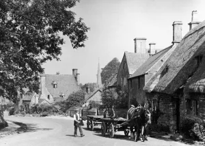 Man with his horse and cart on a country road in the Cotswold village of Stanton