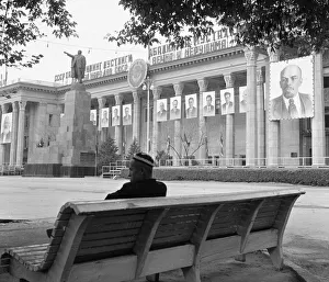 Ussr Prints: A man sits on a public bench in a deserted square in the Soviet city of Tashkent