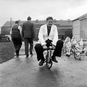 00039 Prints: Man testing childrens toys bicycles and rocking horses. December 1953 D7321