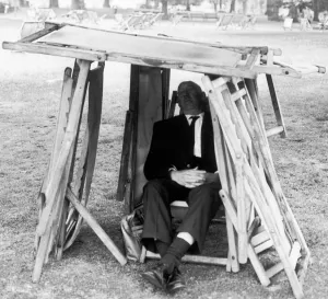 Shade Prints: Man using whatever improvised materials he can find including folded up deckchairs to