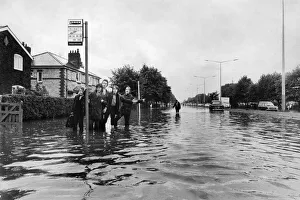Manchester Schoolboys waiting for the next bus on the flooded Kingsway Road in Burnage