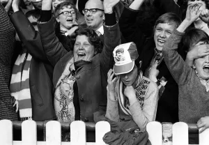 Loneliness Prints: Manchester United Fan wearing George Best hat March 1972 is surrounded by Stoke City fans