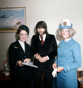 Manchester United footballer George Best with air hostesses before boarding his plane