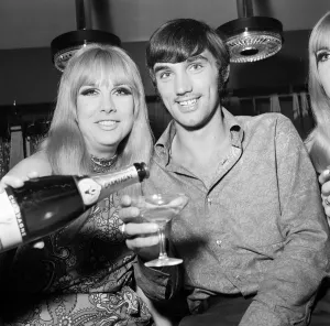 Manchester United footballer George Best celebrates the opening of his fashion boutique