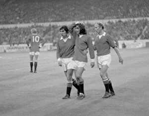 Manchester United footballer George Best is consoled by teammates Tony Dunne (left