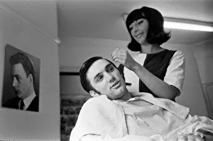 Manchester United footballer George Best has his hair cut by Lynda Cole
