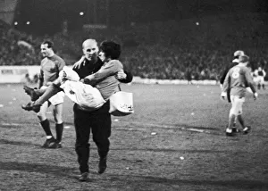 Manchester United footballer George Best is helped off the pitch by trainer Jack