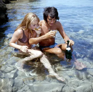 Manchester United footballer George Best on holiday with girlfriend Susan George while