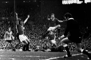 Manchester United footballers Lou Macari and Sammy McIlroy celebrates a goal by Gerry