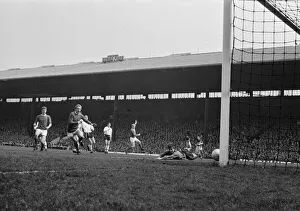 Manchester United forward Bobby charlton raises his arm in celebration after scoring a