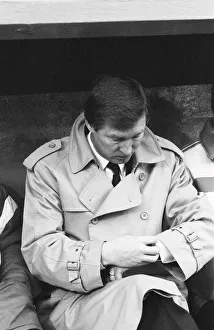 Manchester United manager Alex Ferguson checks his watch in the dugout during the League