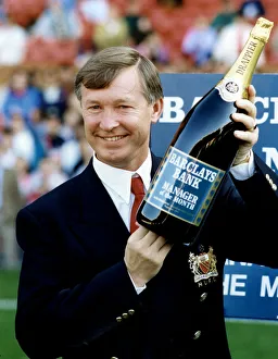 Manchester United manager Alex Ferguson holding a bottle of champagne