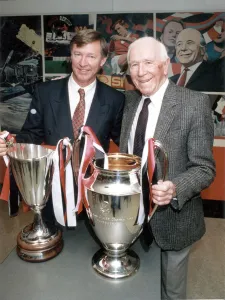 Manchester United manager Alex Ferguson and former manager Sir Matt Busby posing with
