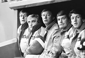 Dugout Prints: Manchester United manager Alex Ferguson sits in the dugout with coaching staff during