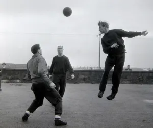 Header Prints: Manchester United player Bobby Charlton jumps up for a header watched by teammates