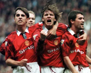 Manchester United Player David Beckham celebrates with team mates Gary Neville (left