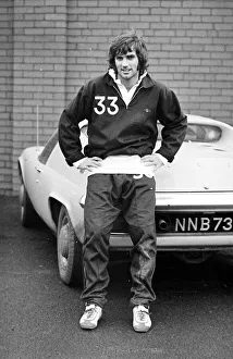 Manchester United star George Best poses next to his Lotus Europa car after a training