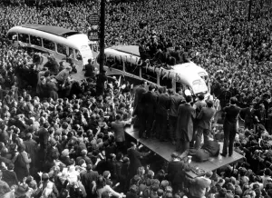 The Manchester United team are greeted by huge crowds in the city centre as they return