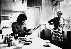 Footballer Prints: Manchester Uniteds George Best enjoys breakfast as landlady Mary Fullaway looks