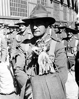Mascot Prints: Maori soldier carries his Maori doll as a mascot as he arrives in Britain to take part in