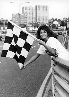 Contest Prints: Maria Stevens, Beauty Queen, holding chequered flag at start of Halfords Birmingham Super