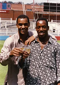 Mark Bright and Ian Wright footballers toast each other with a glass of champagne