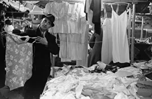 Serving Prints: A market trader modelling ladies underwear to gain a sales in Kingston Market circa 1936