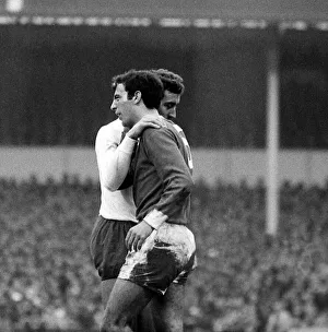 Martin Chivers of Tottenham Hotspur puts his arm round David Sadler of Manchester United