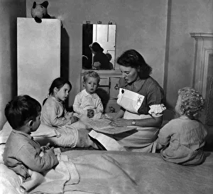 Matron Doris Naughten reads some fairy tales to (left to right) Nigel Paneth, Susan Conen