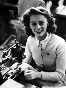 00189 Prints: Mayme Bell Sewing machinist putting buttons onto golf cardigan knitware worker factory