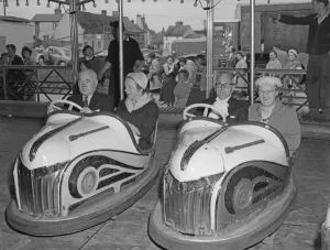 1959 Prints: Mayor Leonard D. V. Wordingham and lady mayoress ride the dodgem cars at the Reach Fair