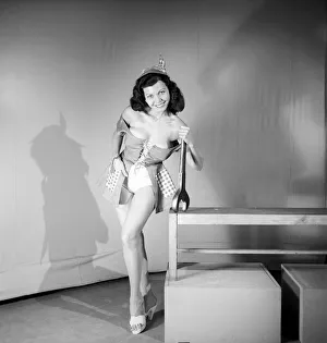The Mechanic: Woman in fancy dress holding large spanner. 1959 E26-001