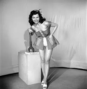 The Mechanic: Woman in fancy dress holding large spanner. 1959 E40-001