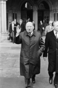 Media Mogul Lew Grade poses outside the High Court in London, smoking one of his cigars